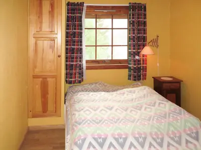 a bedroom with a bed and a window at Chalet Anna by Interhome in Eikelandsosen