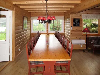 a dining room with a wooden table and chairs at Chalet Julie by Interhome in Eikelandsosen