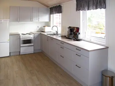 a white kitchen with white appliances and a window at Holiday Home Rød Hytte by Interhome in Herand