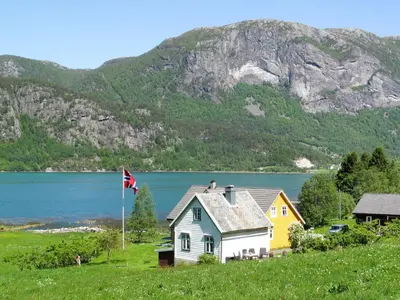 a house with a flag in front of a mountain at Holiday Home Ikjefjord by Interhome in Bjordal