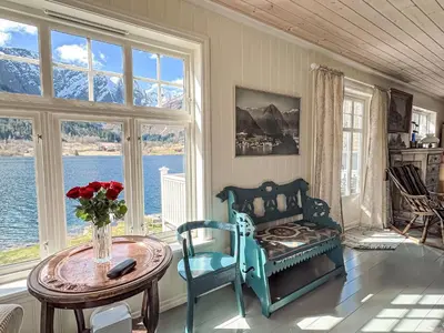 a living room with a table and chairs and a room with windows at Chalet Villa Esefjord by Interhome in Balestrand