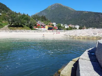 a body of water with a beach and mountains at Chalet Naustet by Interhome in Balestrand