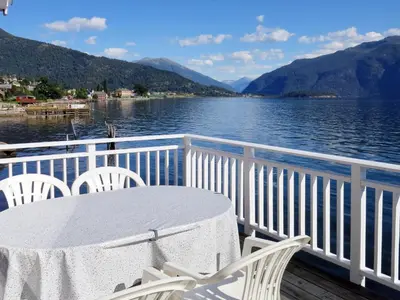 a table and chairs on a deck with a view of a lake at Chalet Naustet by Interhome in Balestrand