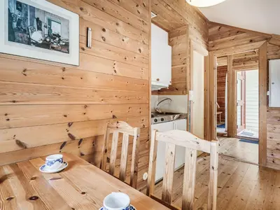 a dining room with wooden walls and a wooden table and chairs at Holiday Home Veganeset I by Interhome in Balestrand