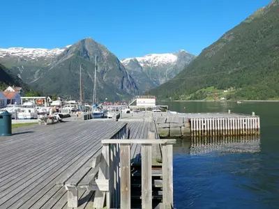 a dock on a lake with mountains in the background at Holiday Home Tantestova by Interhome in Balestrand