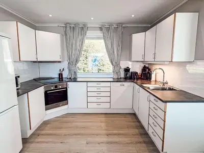 a kitchen with white cabinets and a sink and a window at Holiday Home Tantestova by Interhome in Balestrand
