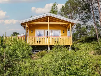 a yellow house on a hill with trees at Holiday Home Granlien by Interhome in Gjølanger