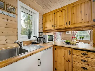 a kitchen with wooden cabinets and a sink and a window at Holiday Home Granlien by Interhome in Gjølanger
