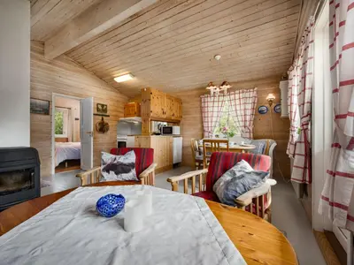 a kitchen and living room with a table and chairs at Holiday Home Granlien by Interhome in Gjølanger