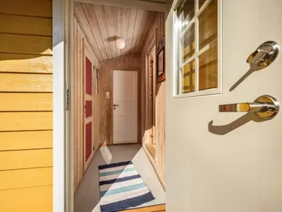 a hallway with a door with a blue and white striped rug at Holiday Home Synnøve by Interhome in Gjølanger
