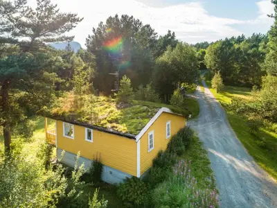 a yellow house with a rainbow on top of it at Holiday Home Synnøve by Interhome in Gjølanger