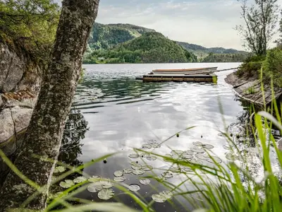 a boat on a lake with mountains in the background at Holiday Home Synnøve by Interhome in Gjølanger