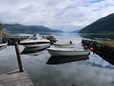 three boats are docked at a dock on a lake at Holiday Home Nausthammar by Interhome in Davik