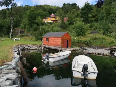 two boats are docked at a dock with a house at Holiday Home Nausthammar by Interhome in Davik
