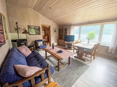 a living room with a blue couch and a table at Holiday Home Nausthammar by Interhome in Davik