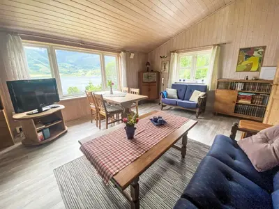 a living room with a blue couch and a table at Holiday Home Nausthammar by Interhome in Davik