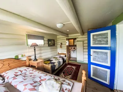 a bedroom with a bed and a couch at Holiday Home Lenebu by Interhome in Syvde