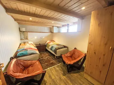 a room with two beds and two chairs in it at Holiday Home Lenebu by Interhome in Syvde