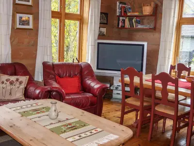 a living room with leather furniture and a television at Holiday Home Elvehuset by Interhome in Holsen