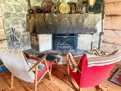 a living room with two chairs and a fireplace at Chalet Haukedalspanorama by Interhome in Holsen