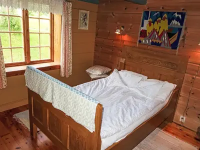 a bedroom with a bed in a log cabin at Chalet Haukedalspanorama by Interhome in Holsen