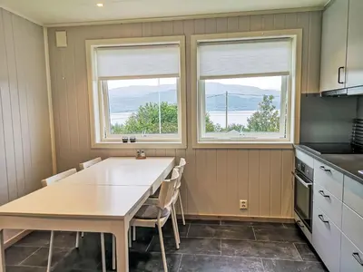 a kitchen with a table and two windows at Apartment Mjellhaugen by Interhome in Naustdal i Sunnfjord