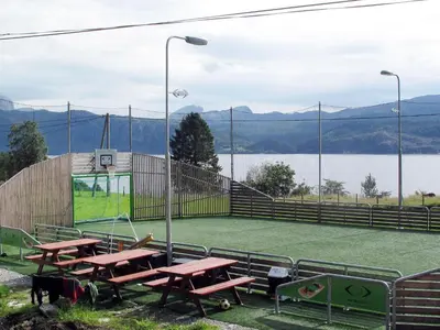 a basketball court with picnic tables and a view of a lake at Holiday Home Rorbu by Interhome in Naustdal i Sunnfjord