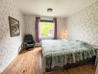 a bedroom with a bed and a chair in it at Holiday Home Kvamsvika by Interhome in Kvammen