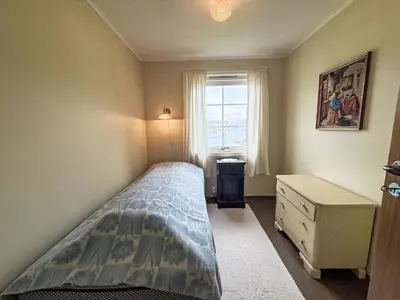 a small bedroom with a bed and a window at Holiday Home Kvamsvika by Interhome in Kvammen