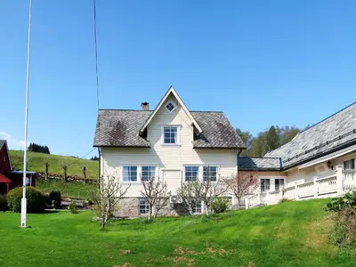 a white house with a yard with green grass at Holiday Home Kvamsvika by Interhome in Kvammen