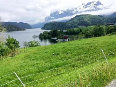 a view of a lake and mountains with a fence at Holiday Home Kvamsvika by Interhome in Kvammen