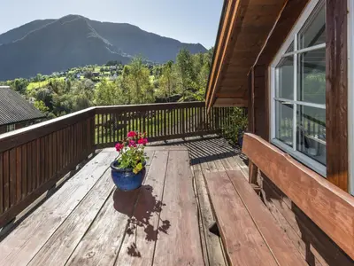 a wooden deck with a pot of flowers on it at Holiday Home Frigg by Interhome in Arnefjord