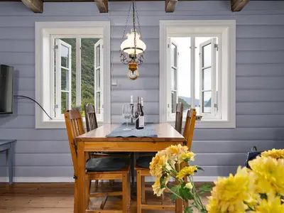 a dining room with blue walls and a table and chairs at Holiday Home Johans Maria stova by Interhome in Arnefjord