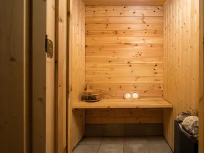 a sauna with a wooden wall and two candles at Holiday Home Tor by Interhome in Arnefjord