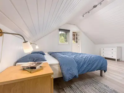 a bedroom with a bed with blue sheets and a table at Holiday Home Odin by Interhome in Arnefjord