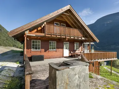 a log cabin with a large porch and a large at Holiday Home Odin by Interhome in Arnefjord