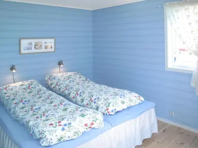 a bed in a blue room with two pillows on it at Apartment Fagerdalsnipi by Interhome in Arnefjord