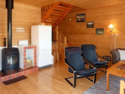 a living room with two chairs and a stove at Holiday Home Jambueggi by Interhome in Arnefjord