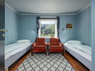 a room with two beds and two chairs and a window at Holiday Home Indresfjord by Interhome in Åse