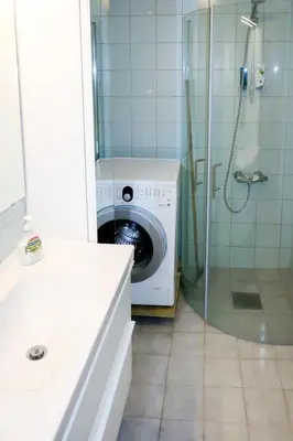 a washing machine in a bathroom with a shower at Holiday Home Solsvika by Interhome in Leirvik