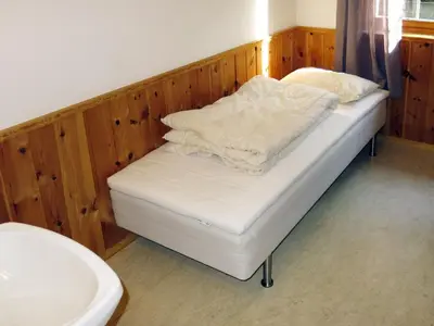 a bed with white sheets on it in a room at Holiday Home Solsvika by Interhome in Leirvik
