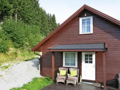 a small house with two chairs in front of it at Holiday Home Peer Gynt by Interhome in Sogndal