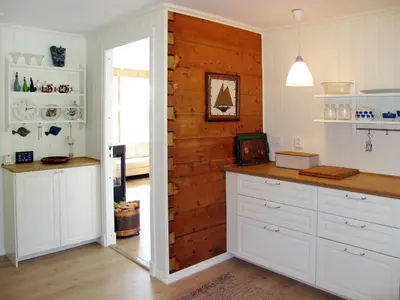 a kitchen with a wooden accent wall and a door at Holiday Home Strøneneset by Interhome in Hagavik