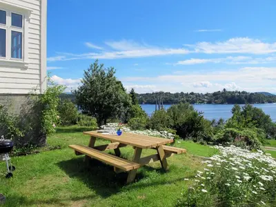 a wooden picnic table in the grass next to a house at Holiday Home Strøneneset by Interhome in Hagavik