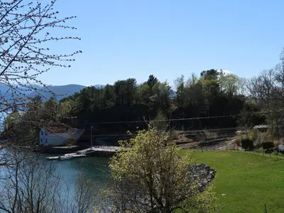 a view of a river with a house and trees at Holiday Home Hjartnesvika by Interhome in Hjartåker