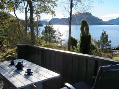 a table on a balcony with a view of a lake at Holiday Home Hjartnesvika by Interhome in Hjartåker