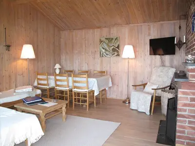 a living room with a table and chairs and a television at Holiday Home Hjartnesvika by Interhome in Hjartåker