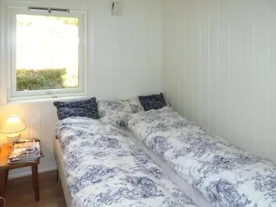 a bedroom with a bed and a window at Holiday Home Hjartnesvika by Interhome in Hjartåker