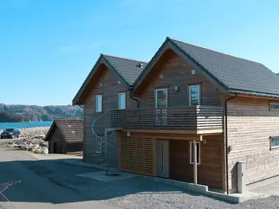 a log cabin with a deck and a garage at Apartment Gurevika by Interhome in Nordhuglo