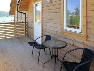 a table and chairs on the porch of a cabin at Apartment Gurevika by Interhome in Nordhuglo
